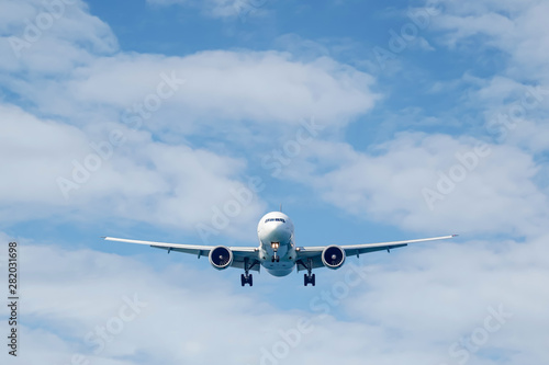Passenger plane in flight. Aircraft fly high in the sky above the clouds. Front view of airplane.
