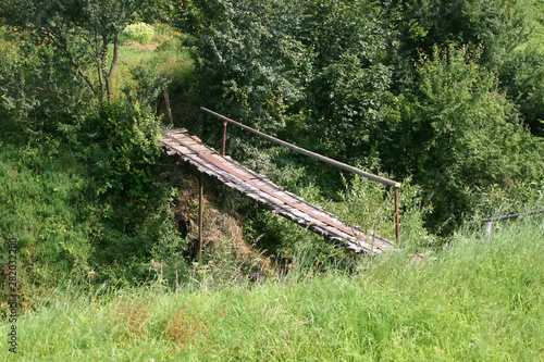 Old bridge over the ravine. Wooden bridge over the river.