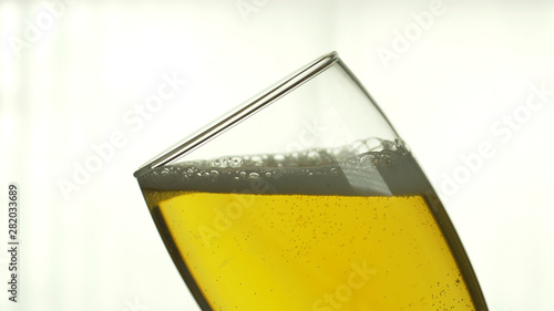 Beer is poured into a glass on an isolated white background.