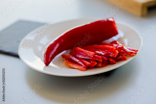 Fresh red hot chili peppers on wooden cutting board , close-up