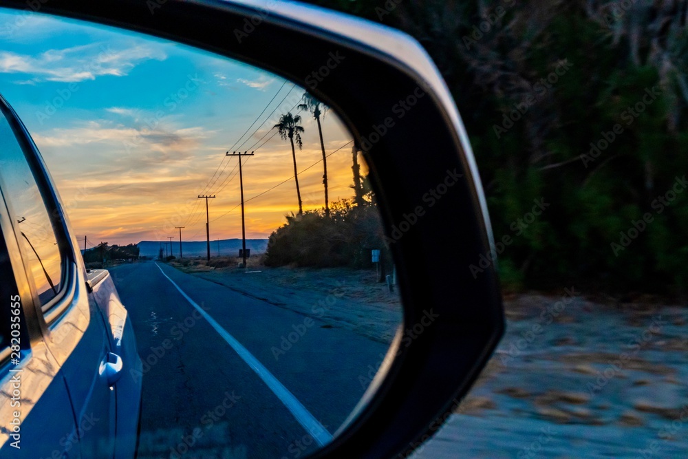 Desert sunrise in a car side mirror 