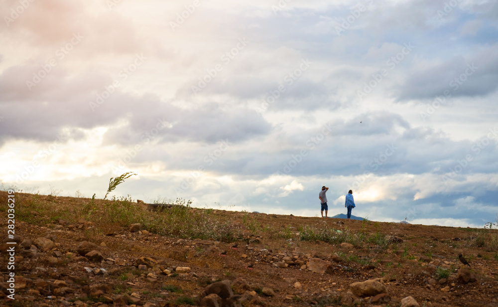 Fototapeta premium landscape at evening time man and woman standing sky background .