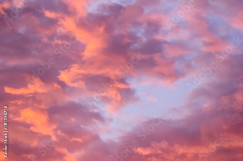Fototapeta Naklejka Na Ścianę i Meble -  The bright orange sun rises against the backdrop of purple clouds