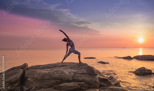 Asian girl practice Yoga on the beach Sunrise morning day