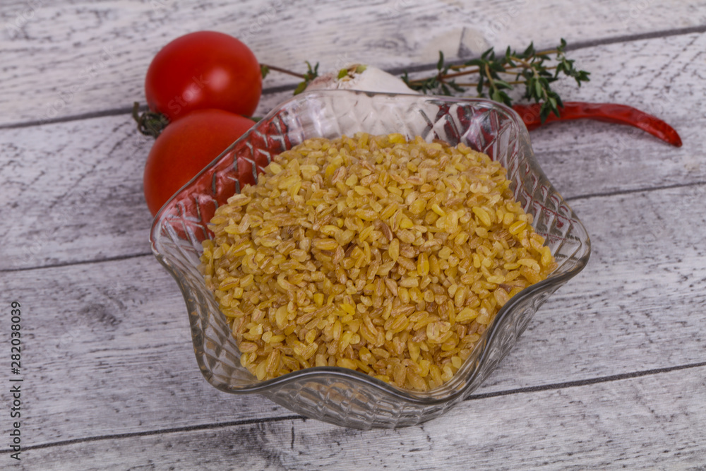 Raw bulgur in the bowl with tomatoes and garlic Raw bulgur in the bowl with tomatoes and garlic