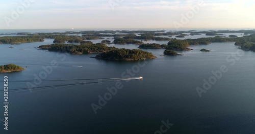 Boat in the Finnish archipelago, Aerial, tracking, drone shot following a motorboat, on the Gulf of Finland, on a summer evening, in Tammisaaren saaristo national park, in Raasepori, Uusimaa, Finland photo