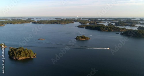 Aerial, reverse, drone shot of boats in the archipelago, on the Baltic sea, on a sunny, summer evening, in Tammisaari saaristo national park, in Raasepori, Uusimaa, Suomi photo