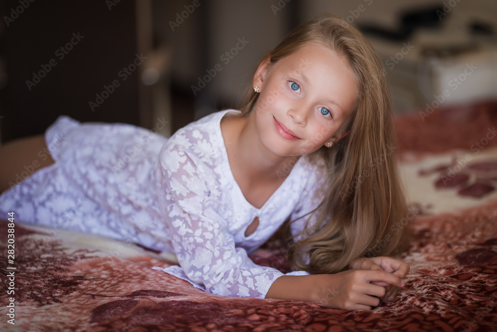 Portrait pretty girl with long hair on the bed. She wears sensual clothes and smiling to camera. Portrait pretty girl with long hair on the bed. She wears sensual clothes and smiling to camera.