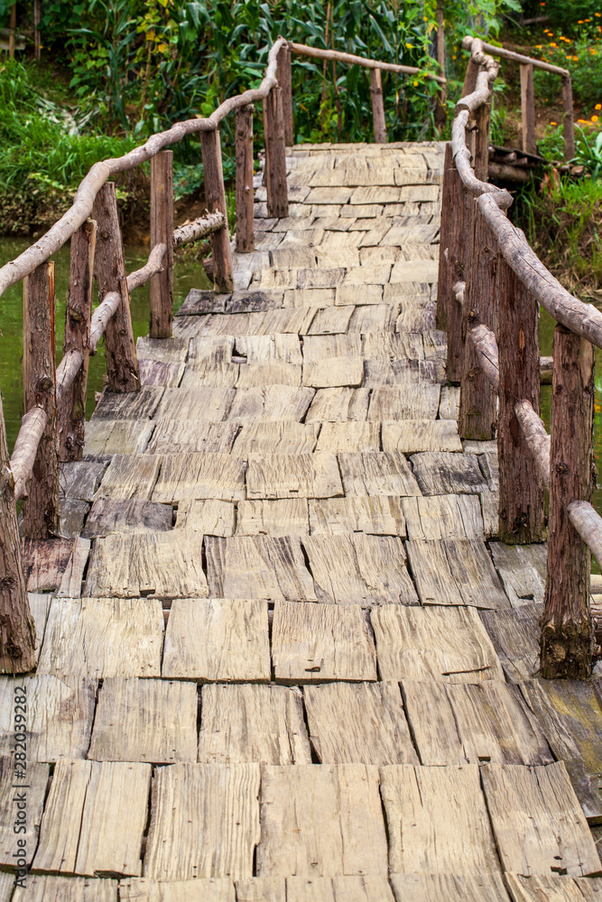 old wooden bridge over a stream, vertical photo