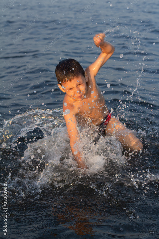 little boy splashing in the sea wave