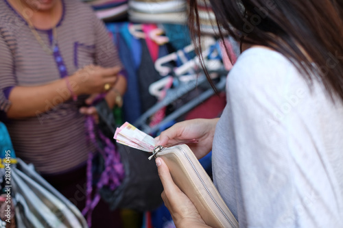 Woman holding cash - purchasing dress