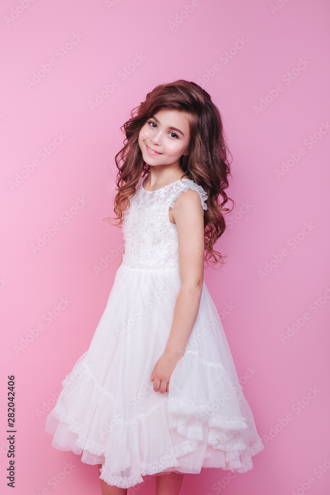 portrait of beautiful little girl in white dress on pink background portrait of beautiful little girl in white dress on pink background