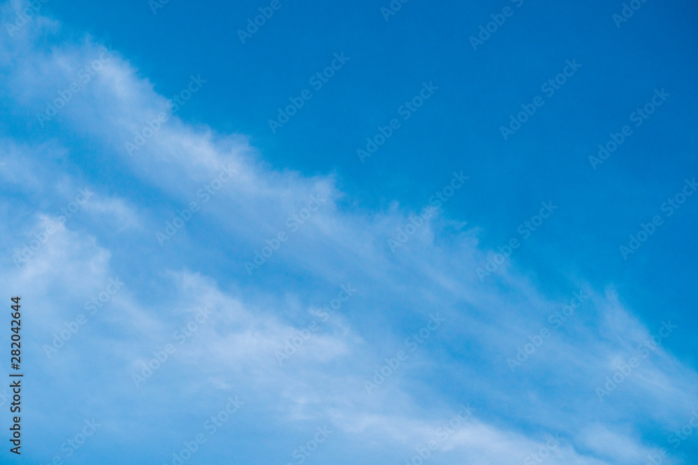 The blue sky with moving white clouds. The sky is a beautiful color shade suitable for use as a background image.