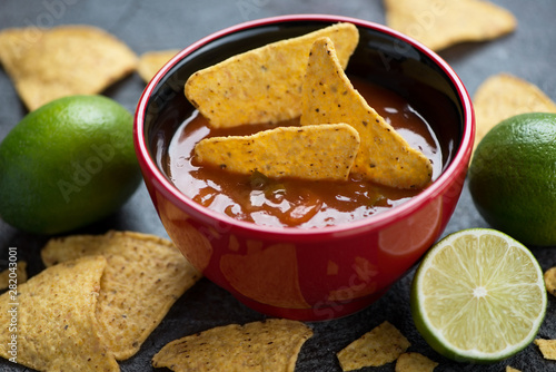 Bowl of salsa sauce with nachos chips, selective focus, studio shot, close-up