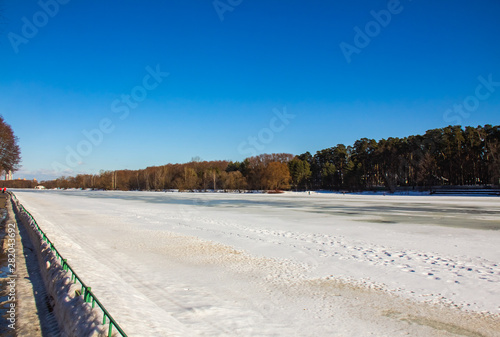 Fototapeta Naklejka Na Ścianę i Meble -  Frozen Moscow River on the background of the Serebryany Bor Forest Reserve and blue sky