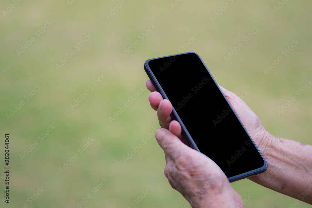 Close-up of wrinkled hands holding a smartphone