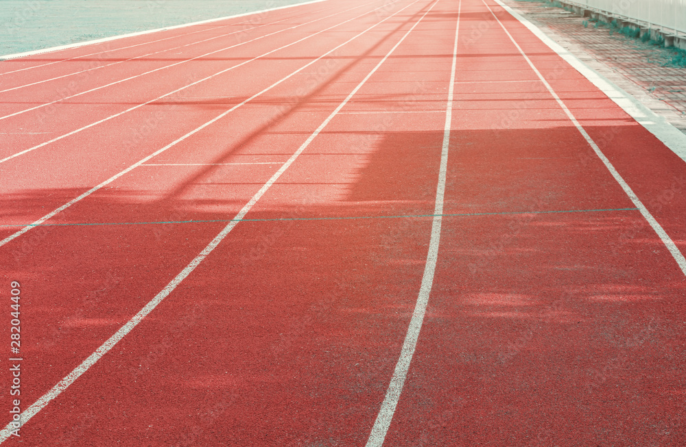 running track red outdoor with white lines and morning sunlight