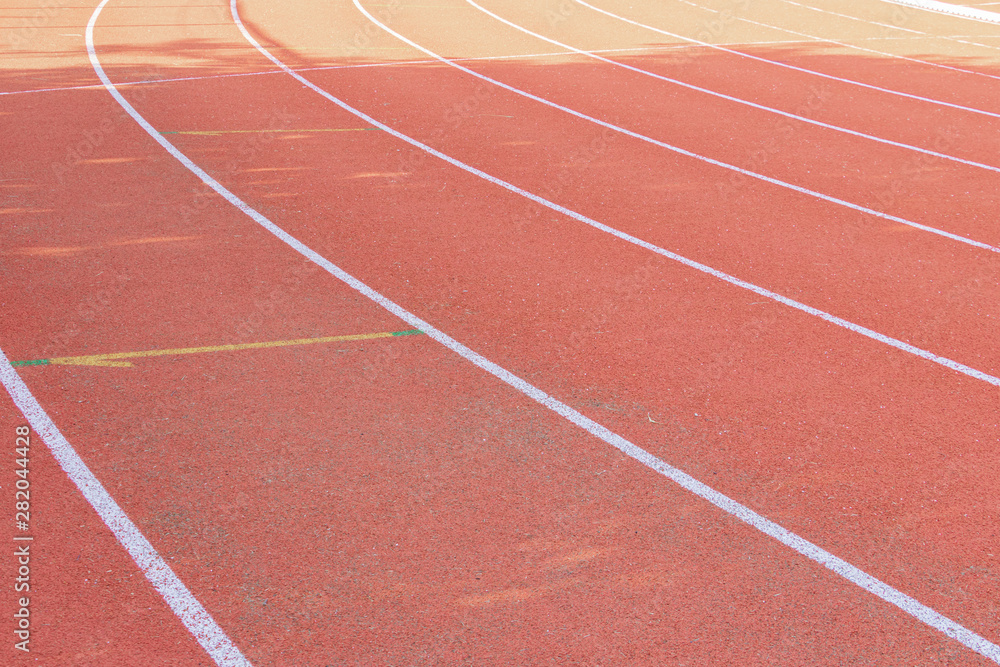 running track red outdoor with white lines and morning sunlight