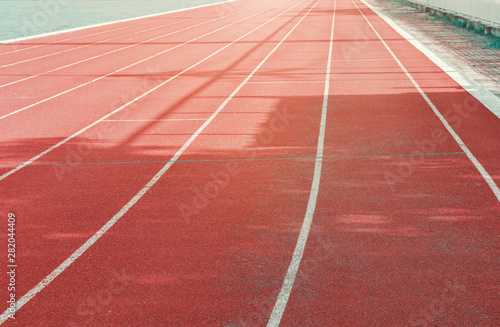 running track red outdoor with white lines and morning sunlight