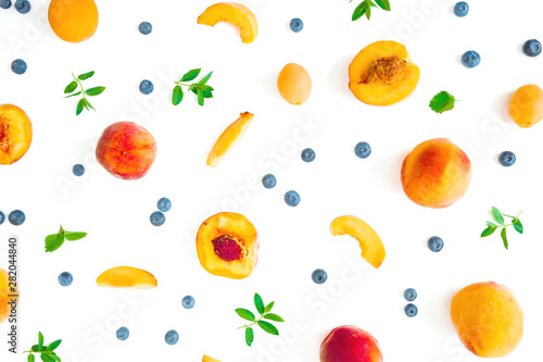 Fruit pattern of ripe peaches, blueberies with mint leaves isolated on white background. Top view. Flat lay