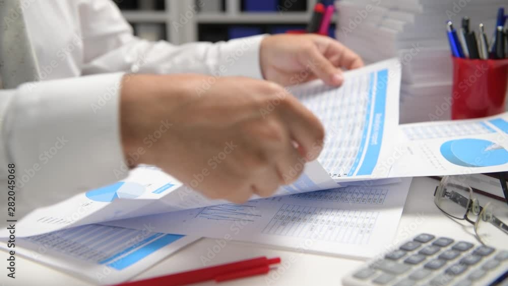Businessman working and calculating, reads and writes reports. Office employee, table closeup. Business financial accounting concept. Businessman working and calculating, reads and writes reports. Office employee, table closeup. Business financial accounting concept.