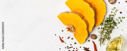 Slices of ripe pumpkin with spices and olive oil. Autumn food concept. Banner for site