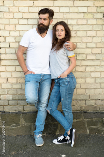 Family day. Careful hug of loving people. Just hang out together. Couple in love. Family couple hugging on brick wall background. Bearded man and sexy woman cuddling. Sensual couple together