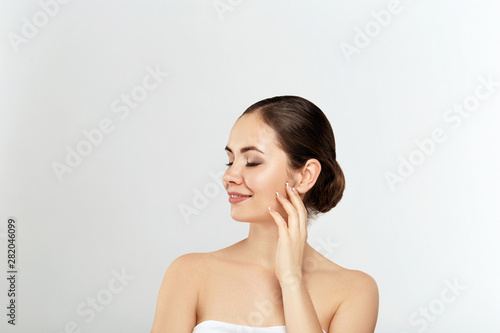 Healthy woman spa model with clear skin on gray background