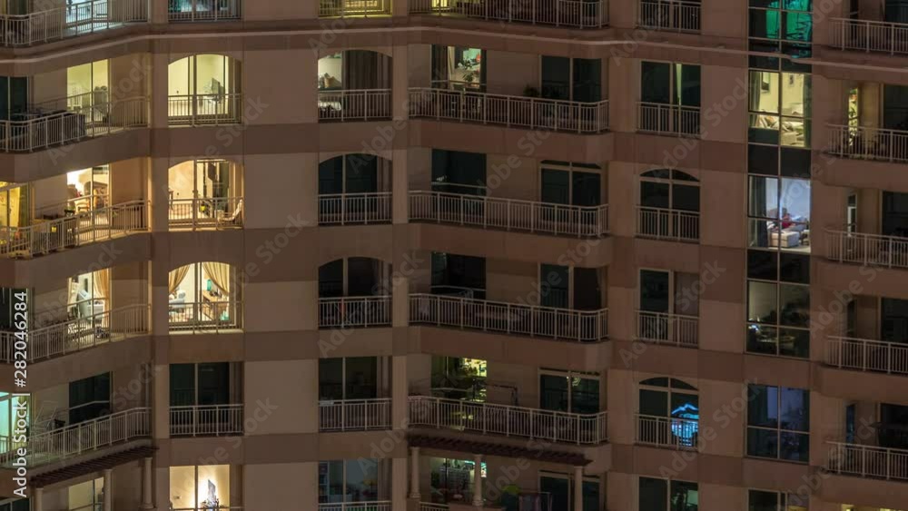 Glowing windows of the multi-storey building with lighting inside and moving people in apartments timelapse. Aerial view of modern residential skyscrapers in Dubai greens district Glowing windows of the multi-storey building with lighting inside and moving people in apartments timelapse. Aerial view of modern residential skyscrapers in Dubai greens district