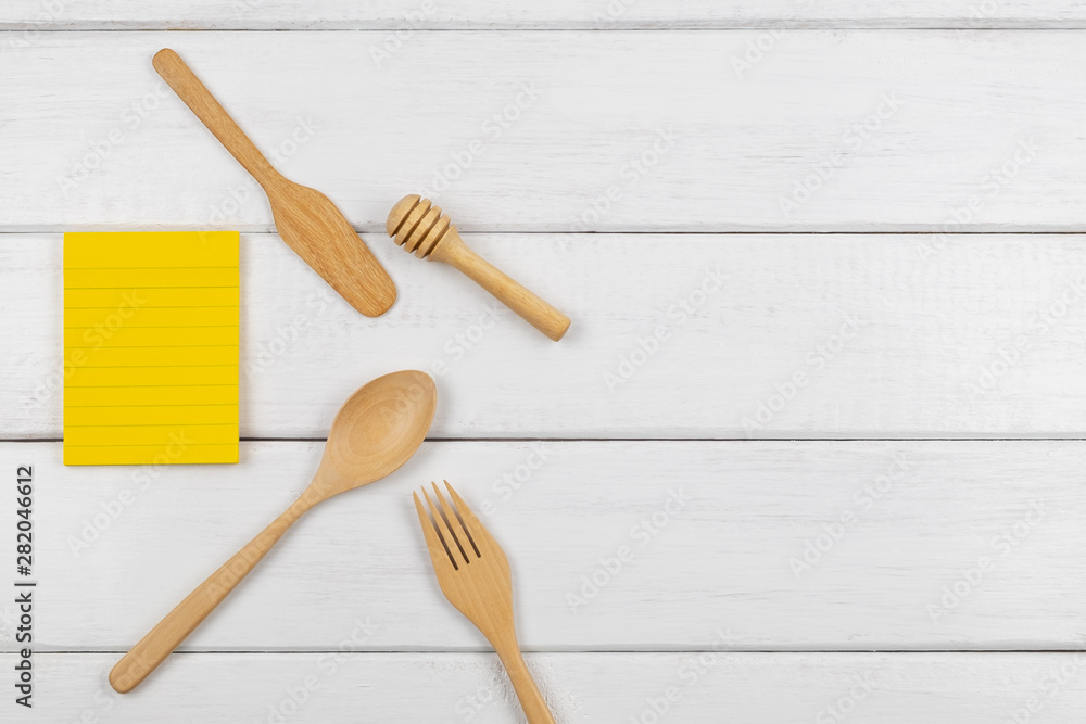 Top view of a yellow blank sticky note with eating utensils Top view of a yellow blank sticky note with eating utensils