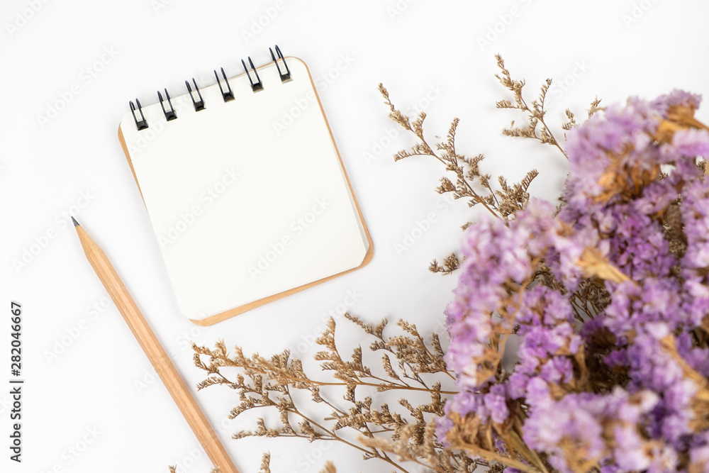 Top view of a blank paper note with pencil and flower bouquet Top view of a blank paper note with pencil and flower bouquet