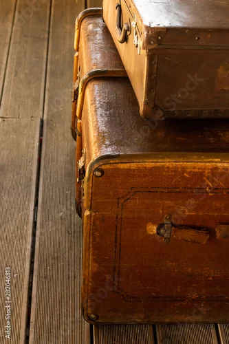 Obraz retro duża brązowa walizka pionowa fotografia tradycyjna skórzana walizka niezawodna