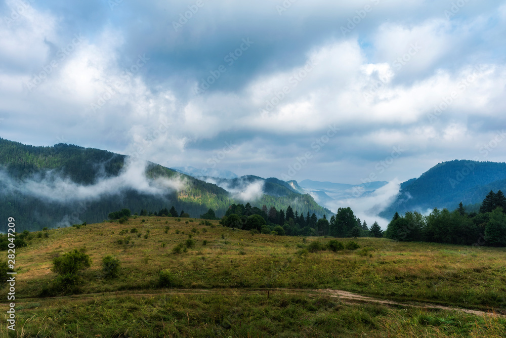 Foggy morning panorama of mountains valley. Splendid summer sunrise in Rhodope mountains, Bulgaria, Europe. Beauty of nature concept background.