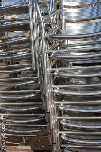 Abstract of stacked tubular steel chairs. © Melvin