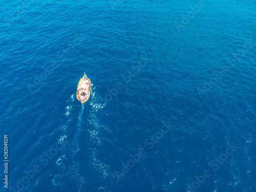 Traditional Maltese fishermen boat at dawn fishing near coast of marsaxlokk. Turquoise blue sea water, top view.