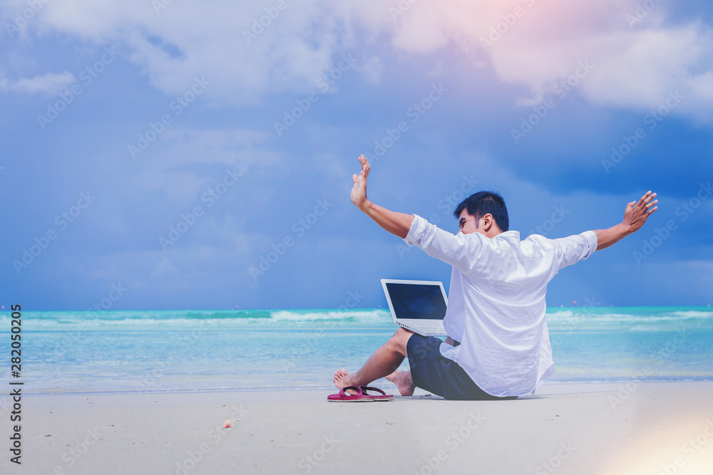 Young man with laptop computer during tropical beach vacation Young man with laptop computer during tropical beach vacation