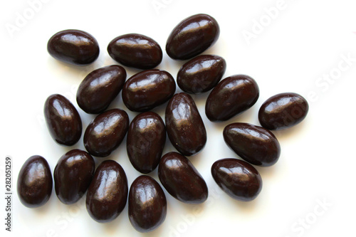 Dark chocolate covered almond candies on white background