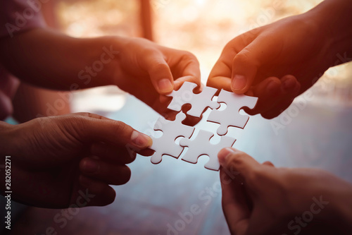 Closeup hand of business people connecting jigsaw puzzle with sunlight effect, Business solutions and represent team support and help concept, success and strategy concept photo
