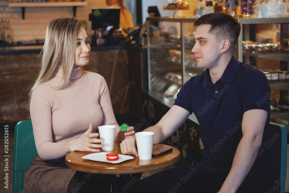Two cute young students — boy and girl, sit in a cafe. Two cute young students — boy and girl, sit in a cafe.