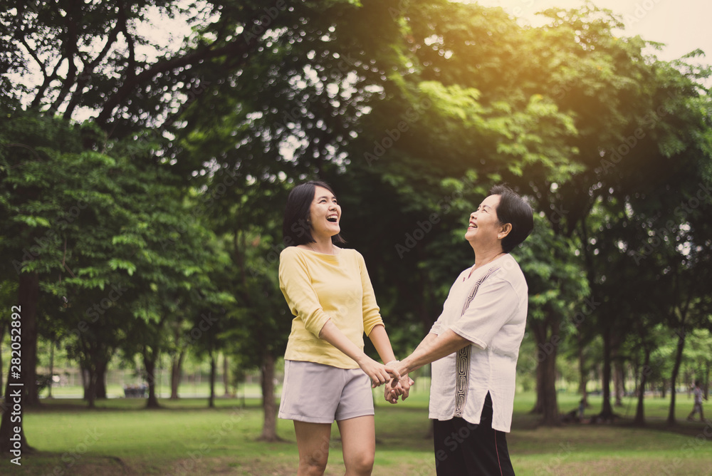 Fototapeta premium Happy two woman hands holding together at public park in the morning,Happy and smiling,Positive thinking,Healthy and lifestyle concept