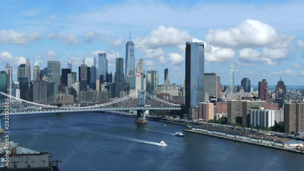 Slow rising right to left aerial of freedom tower skyline and Manhattan bridge; cloudscape; beautiful Slow rising right to left aerial of freedom tower skyline and Manhattan bridge; cloudscape; beautiful