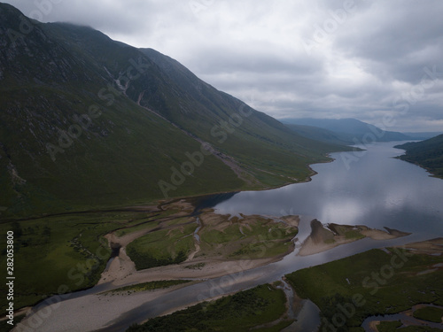 aerial viewpoint of loch etive at the foot of glen etive near glen coe in the argyll region of scotland in summer showing green fields and misty mountains with calm waters on the loch photo