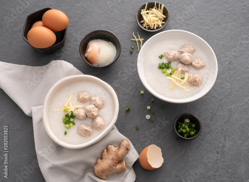 Rice congee with minced pork in white bowl. Bowl of rice porridge with soft boiled egg. Asian breakfast