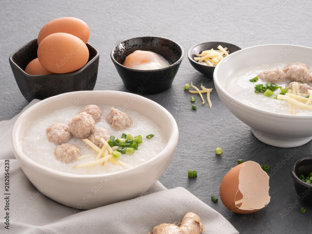 Rice congee with minced pork in white bowl. Bowl of rice porridge with soft boiled egg. Asian breakfast Rice congee with minced pork in white bowl. Bowl of rice porridge with soft boiled egg. Asian breakfast