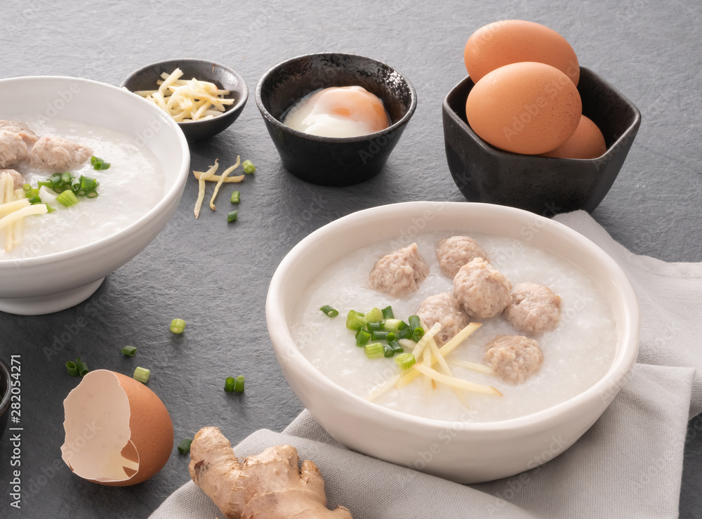 Rice congee with minced pork in white bowl. Bowl of rice porridge with soft boiled egg. Asian breakfast Rice congee with minced pork in white bowl. Bowl of rice porridge with soft boiled egg. Asian breakfast