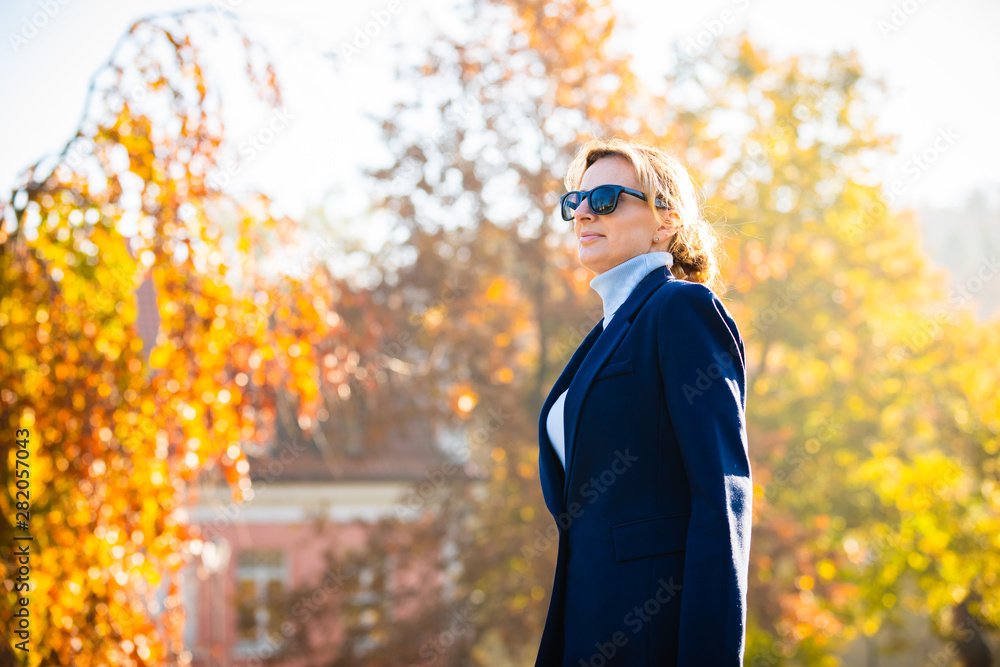 Middle-aged woman walking in city park Middle-aged woman walking in city park