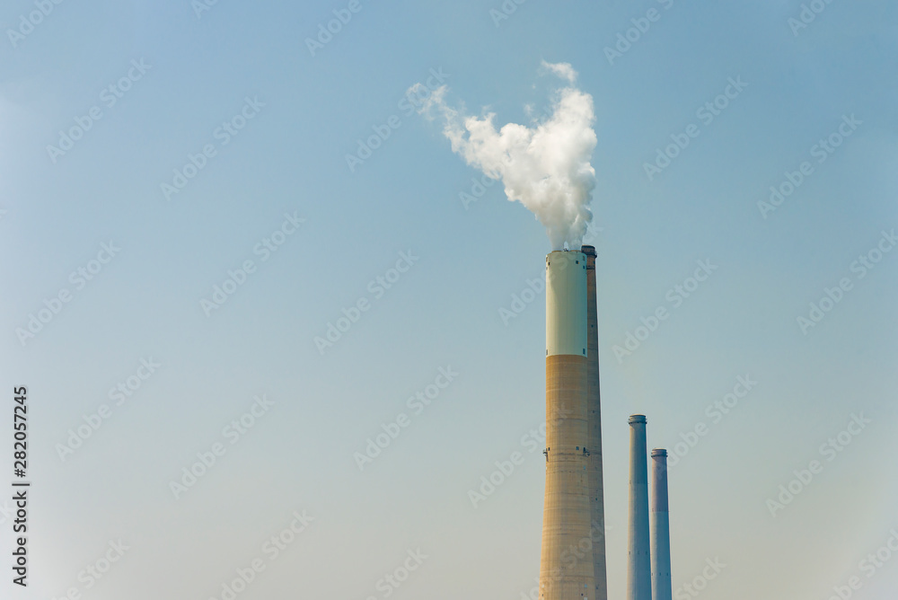 The pipe from which the smoke goes against the gray sky. The concept of air pollution. The pipe from which the smoke goes against the gray sky. The concept of air pollution.