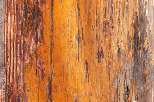 Peeling orange paint of old brown wood desk. scratched wooden flooring with lacquer peeled off– background for design.