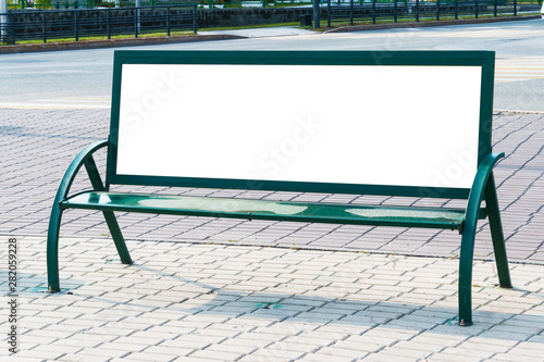 Billboard with blank white copy space for text message or content, mock up banner on a city bench, illuminated by sunlight 