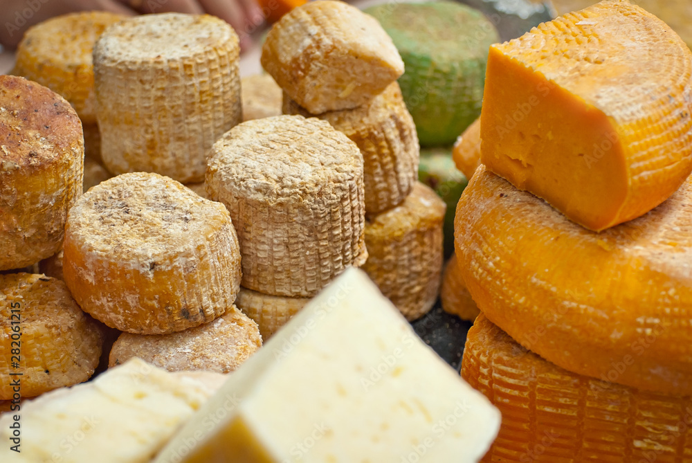 Different types of cheese on the table. Many cheese is sold at an agricultural fair. Natural home product.